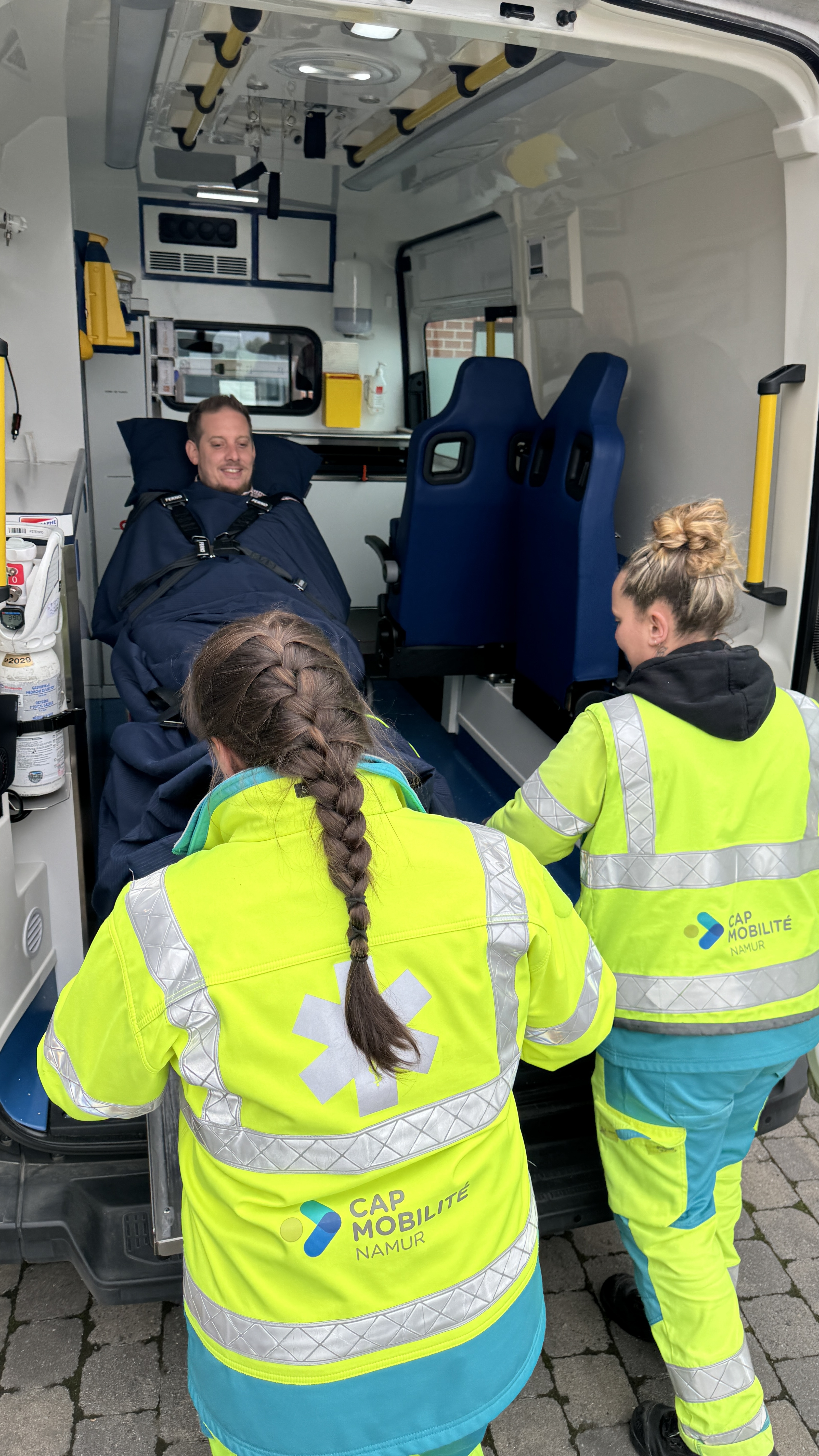 2 ambulanci&egrave;res de chez CAP Mobilit&eacute; Namur prenant en charge un patient.